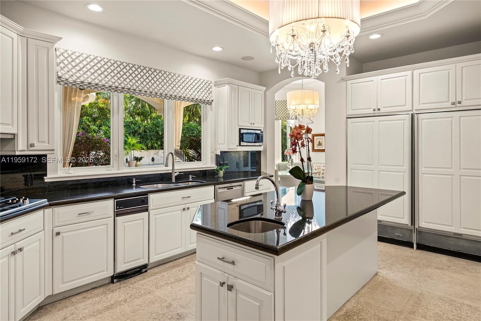 8400 School House Road Miami, FL 33143 - Photo 28 of 66 a kitchen with white cabinets and chandelier