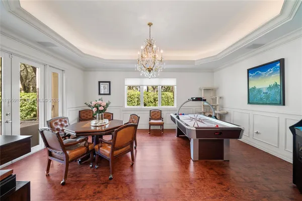 a hallway with white cabinets and chandelier