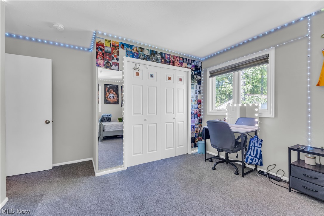 6821 Thornapple Road Gates Mills, OH 44040 - Photo 22 of 42 Carpeted room featuring a double-paned window, bi-fold closet doors, a full-length mirrored wall panel, and neutral wall paint