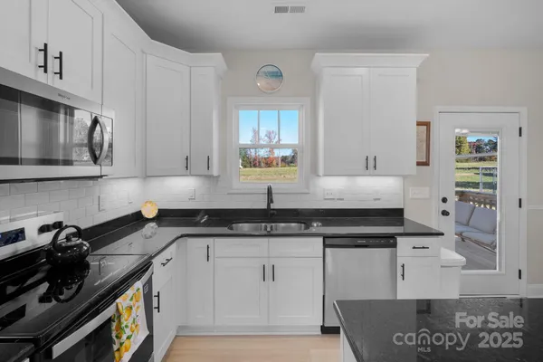 a view of a dining room with furniture a rug and a chandelier