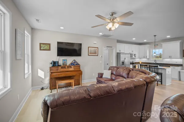 a living room with furniture a flat screen tv and a window