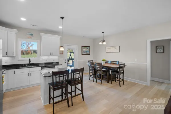 a kitchen with kitchen island a dining table and chairs