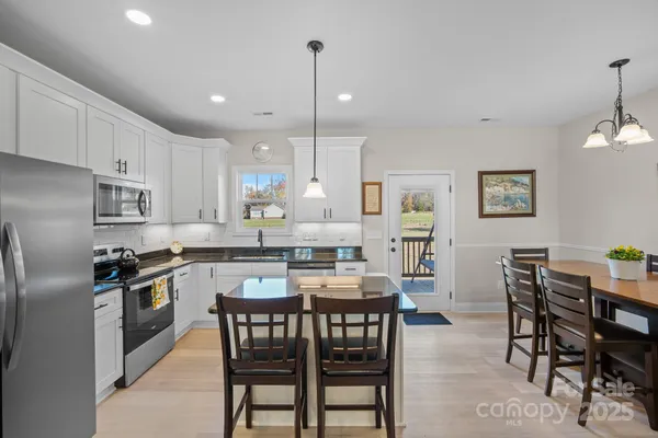 a large kitchen with stainless steel appliances granite countertop a sink a stove and a refrigerator