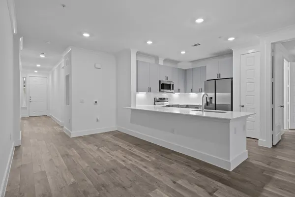 a large white kitchen with a refrigerator a stove top oven a sink and dishwasher