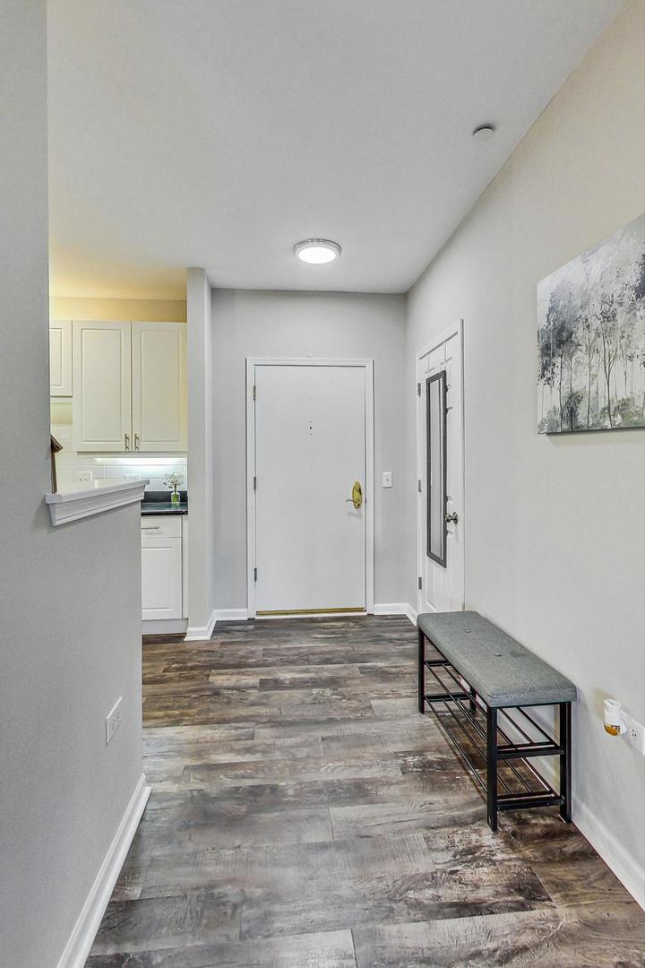 640 McHenry Road, Unit 203 Wheeling, IL 60090 - Photo 11 of 41 a view of a livingroom with wooden floor and cabinet