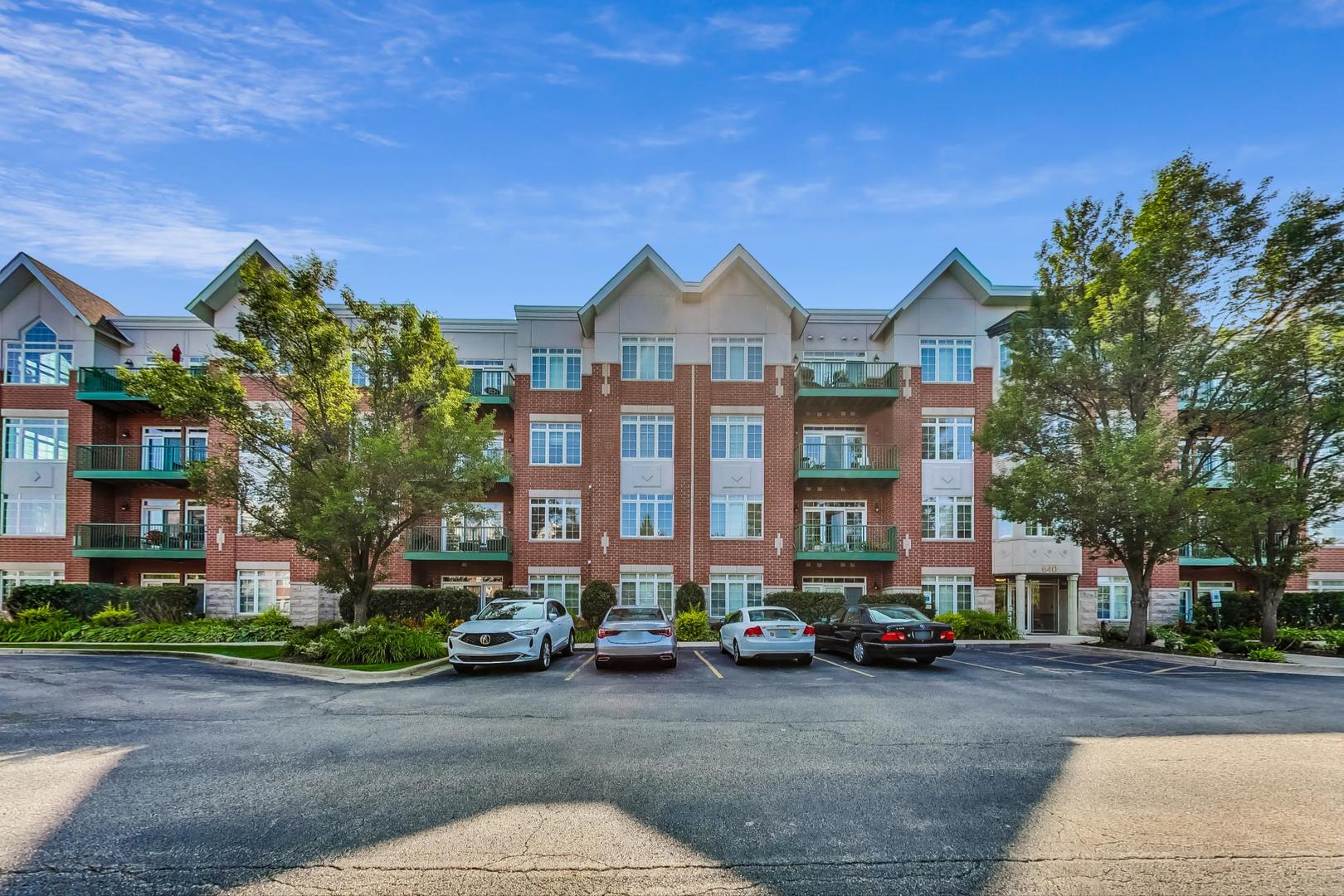640 McHenry Road, Unit 203 Wheeling, IL 60090 - Photo 2 of 41 a front view of a building with lot of cars parked on road