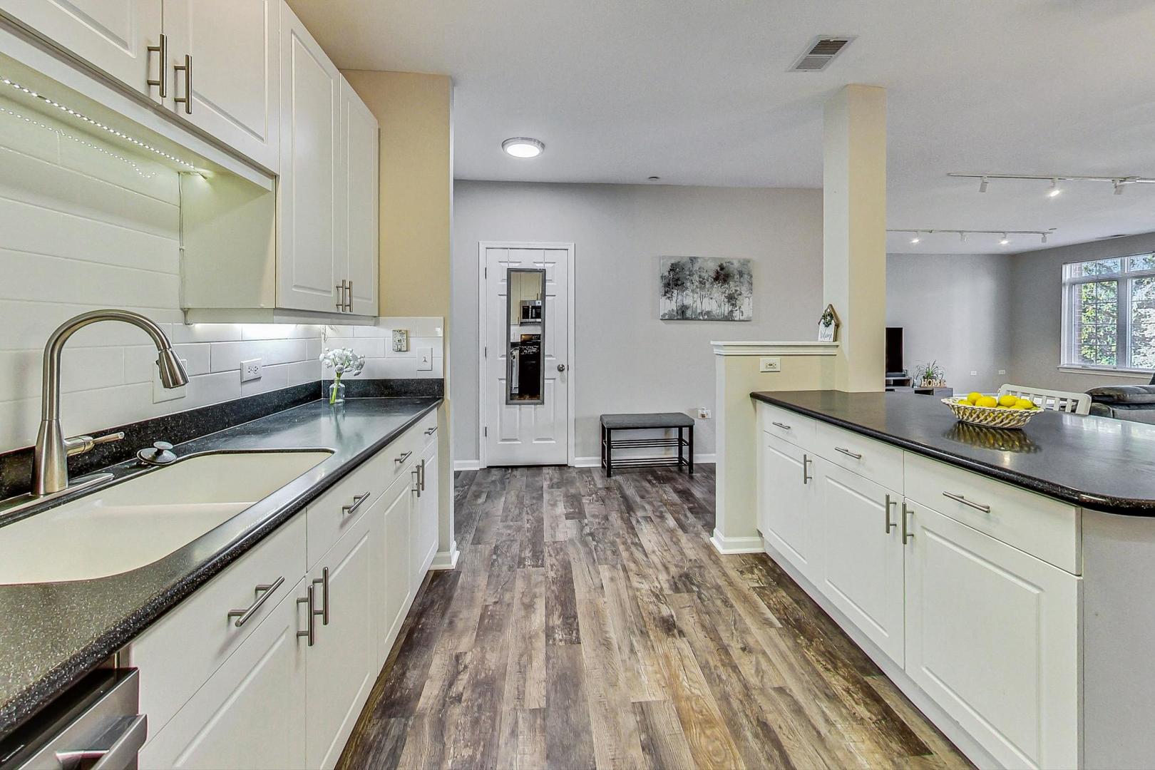 640 McHenry Road, Unit 203 Wheeling, IL 60090 - Photo 21 of 41 a kitchen with granite countertop a sink stove and cabinets