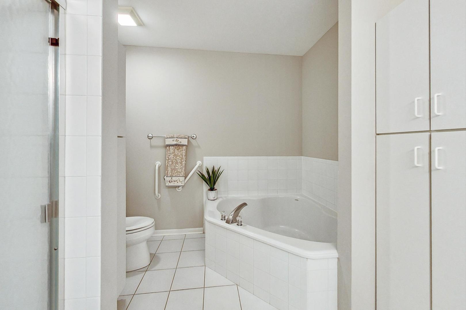 640 McHenry Road, Unit 203 Wheeling, IL 60090 - Photo 27 of 41 a white bath tub sitting next to a white toilet