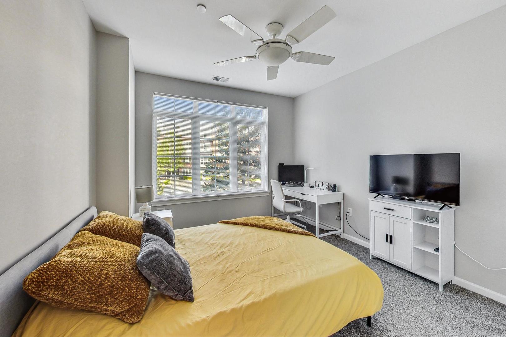 640 McHenry Road, Unit 203 Wheeling, IL 60090 - Photo 28 of 41 a bedroom with a bed and a flat screen tv