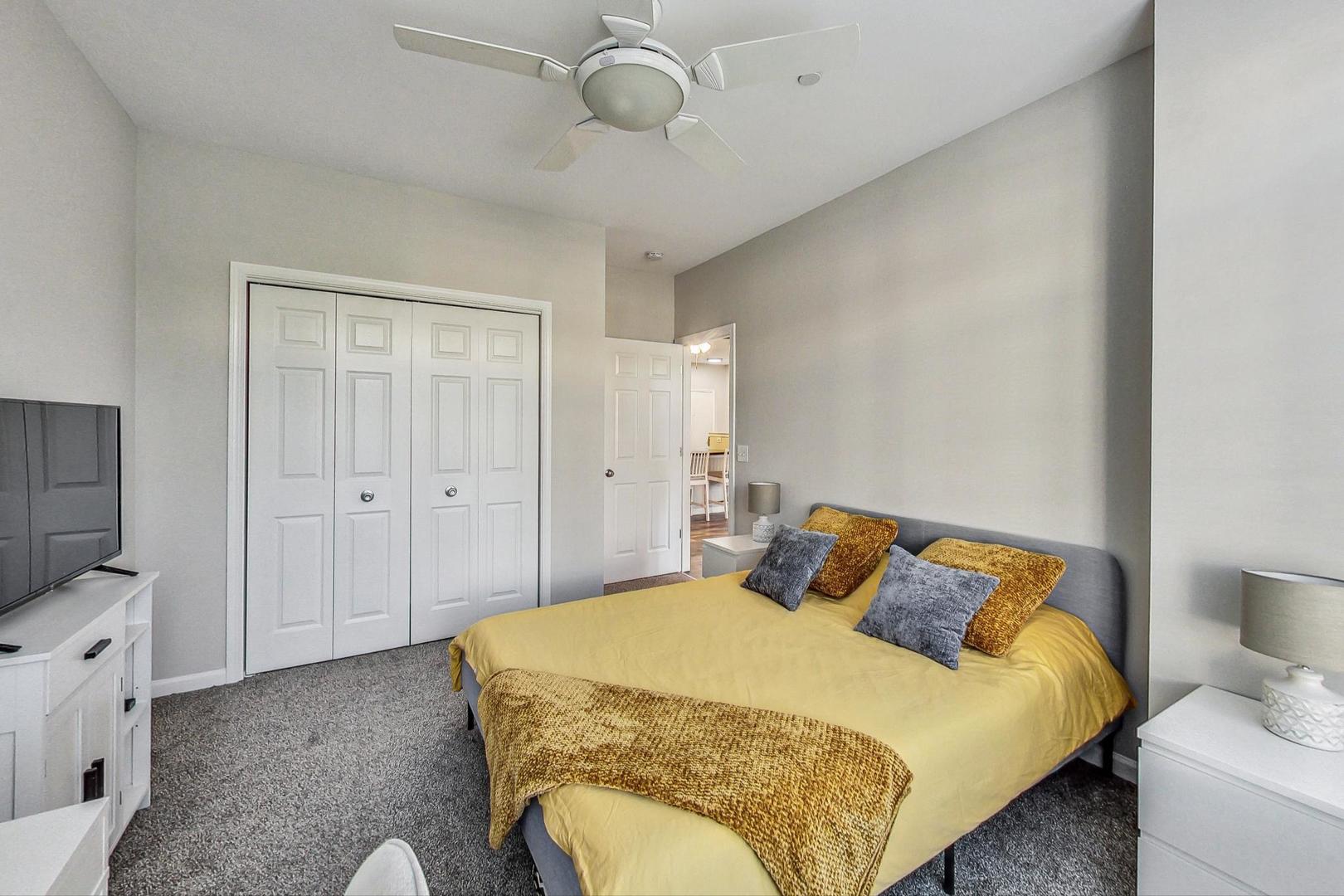 640 McHenry Road, Unit 203 Wheeling, IL 60090 - Photo 29 of 41 a bedroom with a bed and a flat tv screen on the dresser