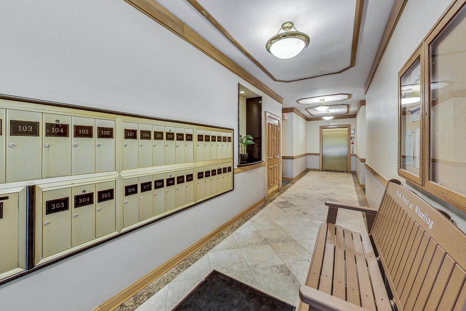 640 McHenry Road, Unit 203 Wheeling, IL 60090 - Photo 7 of 41 a view of a hallway with wooden floor