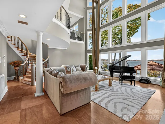 a living room with furniture a large window and a chandelier