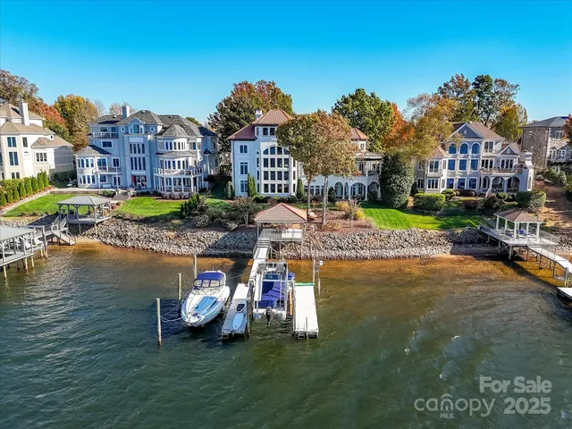 a front view of a house with a garden and lake view