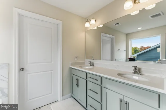 a bathroom with a double vanity sink and a mirror