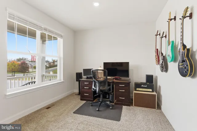a view of a workspace with furniture and a window