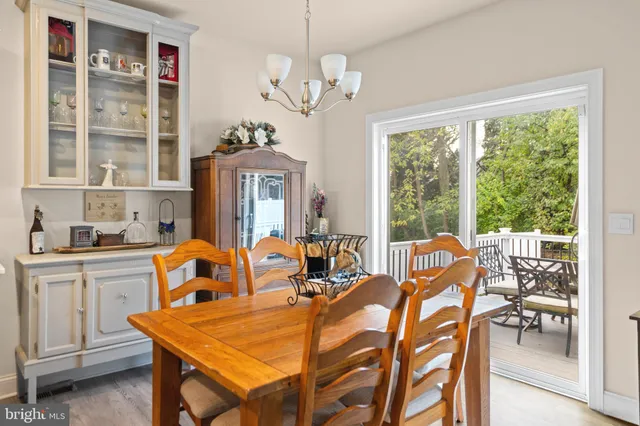 a dining room with furniture a chandelier and a large window