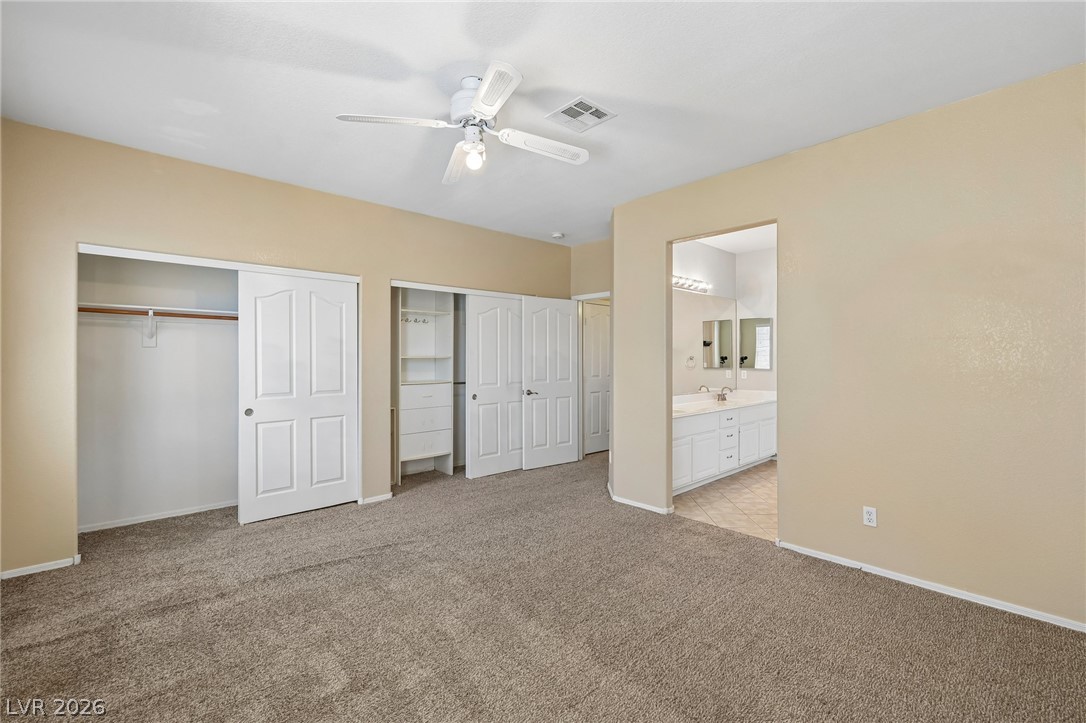 1727 Millstream Way Henderson, NV 89074 - Photo 24 of 46 Comfortable carpeted bedroom featuring ample closet space and convenient access to a private bathroom.