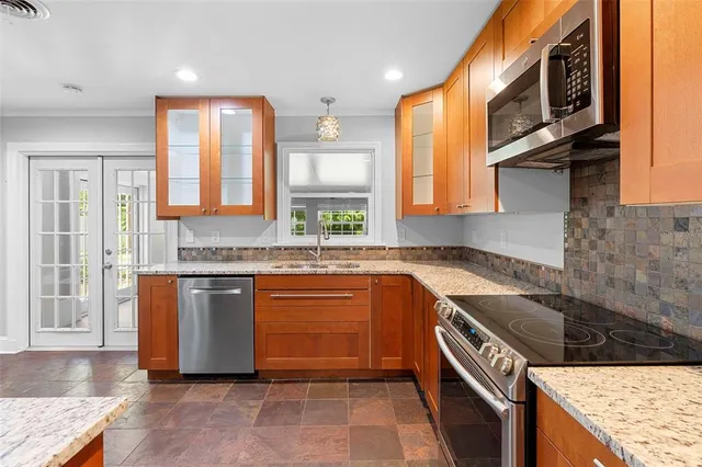 a kitchen with stainless steel appliances granite countertop a stove a sink and a microwave