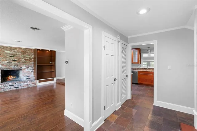 a hallway with wooden floor a fireplace and entryway