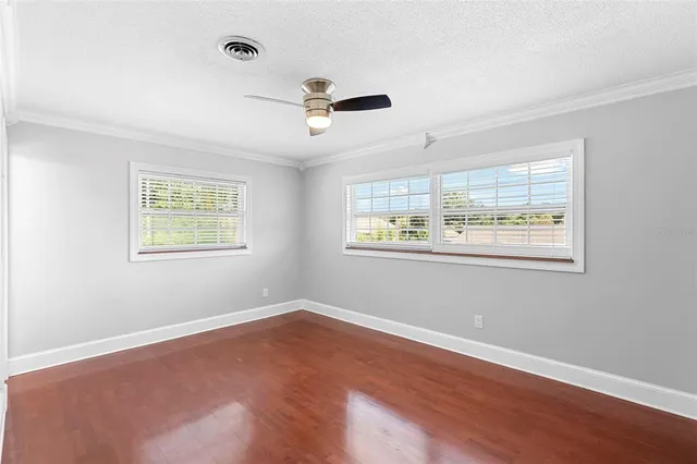 a view of wooden floor in an empty room with a window
