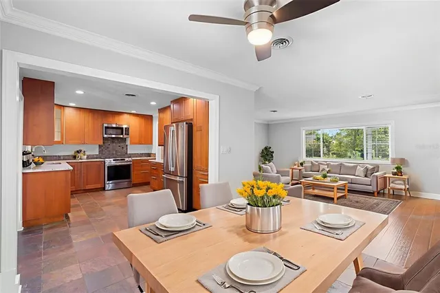 a dining room with furniture a large window and kitchen view