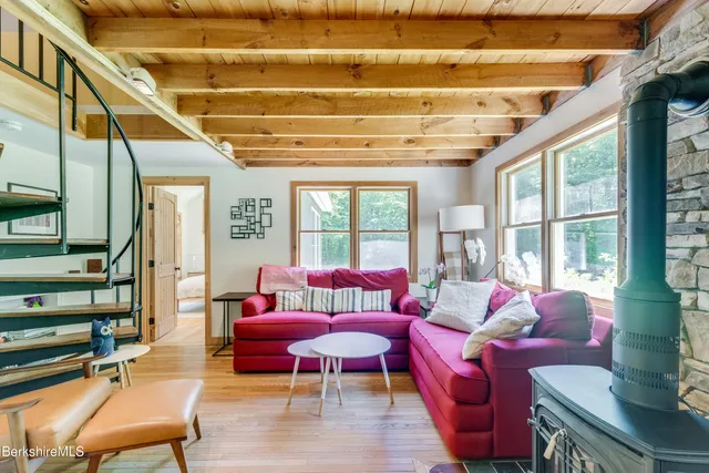 a living room with furniture a wooden floor and a large window