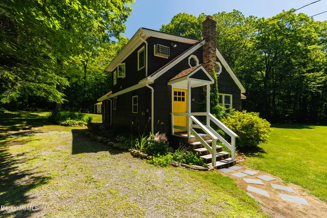 a front view of a house with a yard and trees