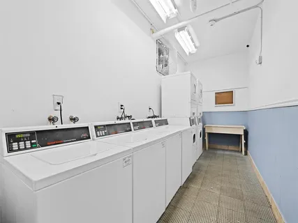 a utility room with stainless steel appliances a sink and cabinets