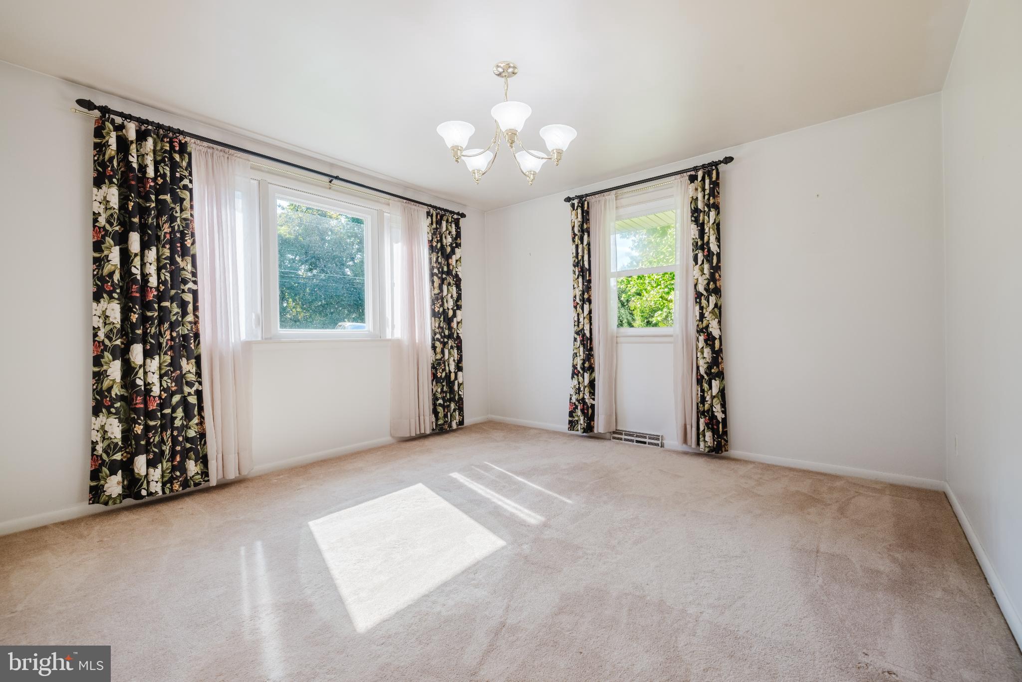 814 West Padonia Road Cockeysville, MD 21030 - Photo 7 of 28 an empty room with windows chandelier fan and wooden floor