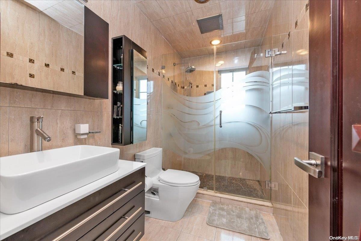 153-02 77th Avenue Queens, NY 11367 - Photo 11 of 23 a bathroom with a sink a toilet and shower