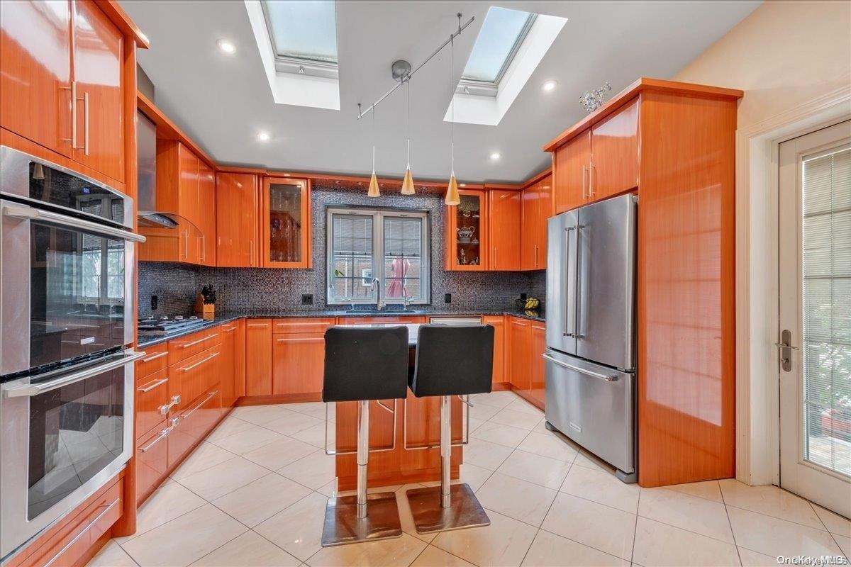 153-02 77th Avenue Queens, NY 11367 - Photo 6 of 23 a large kitchen with granite countertop a refrigerator and a stove top oven