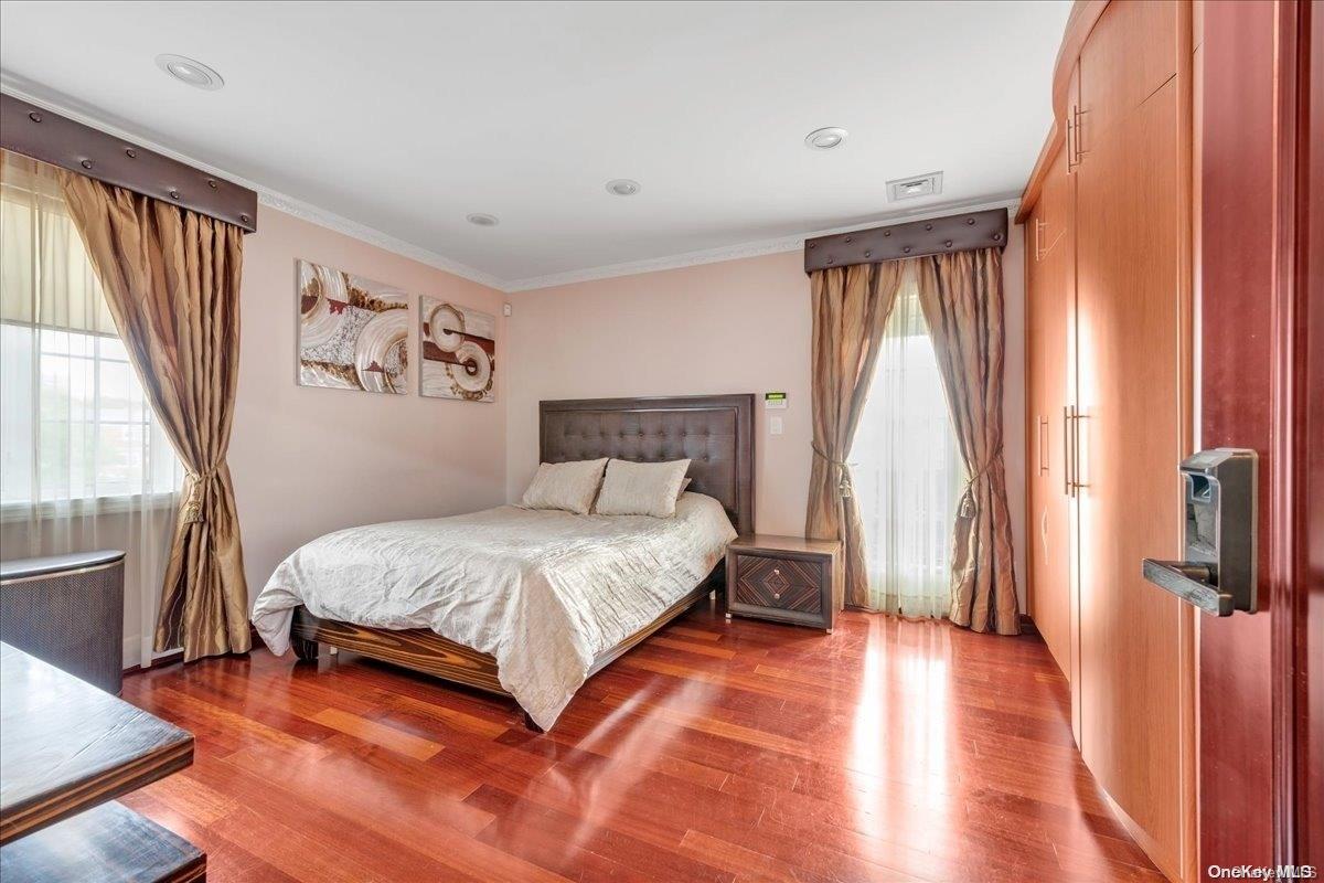 153-02 77th Avenue Queens, NY 11367 - Photo 7 of 23 a bedroom with a bed and a large window