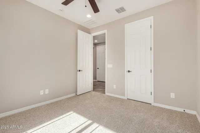 an empty room with a ceiling fan and entryway