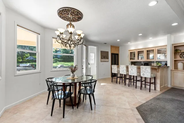 a dining room with furniture a chandelier and window