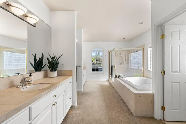 a bathroom with a tub sink and mirror