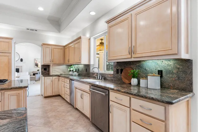 a kitchen with granite countertop a sink stainless steel appliances and cabinets