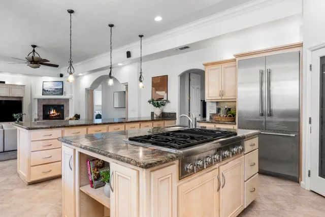 a kitchen with stainless steel appliances granite countertop a stove a sink and a refrigerator