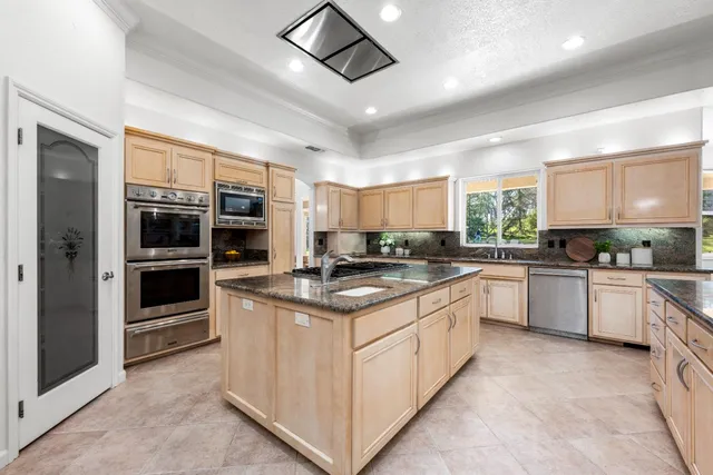 a kitchen with stainless steel appliances granite countertop a stove and cabinets