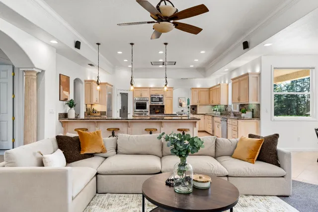 a living room with furniture kitchen and a large window