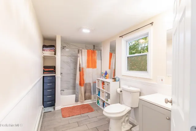 a bathroom with a sink toilet vanity and shower