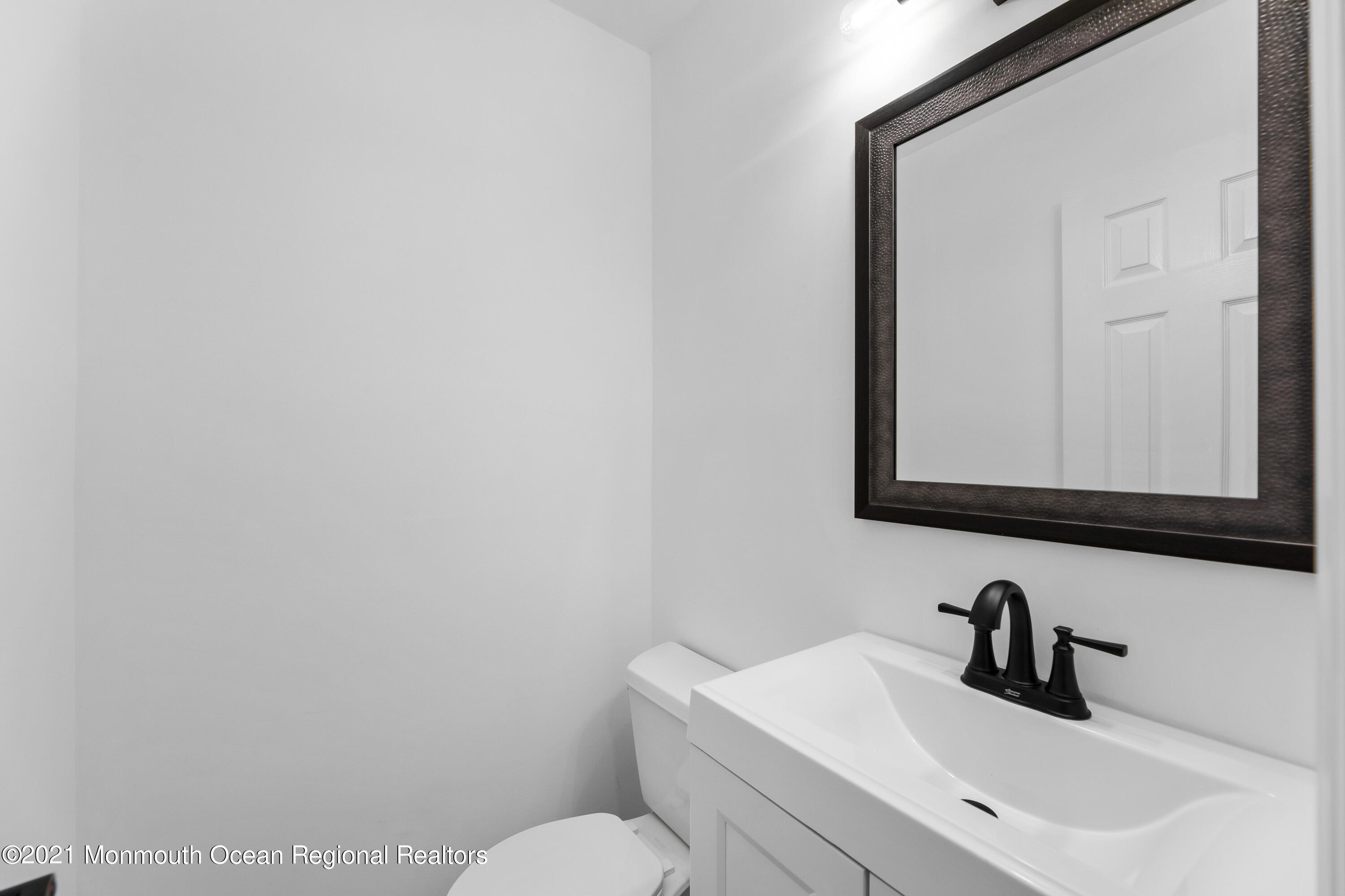 26 Squan Road Millstone Township, NJ 08510 - Photo 11 of 24 a bathroom with a toilet sink and mirror