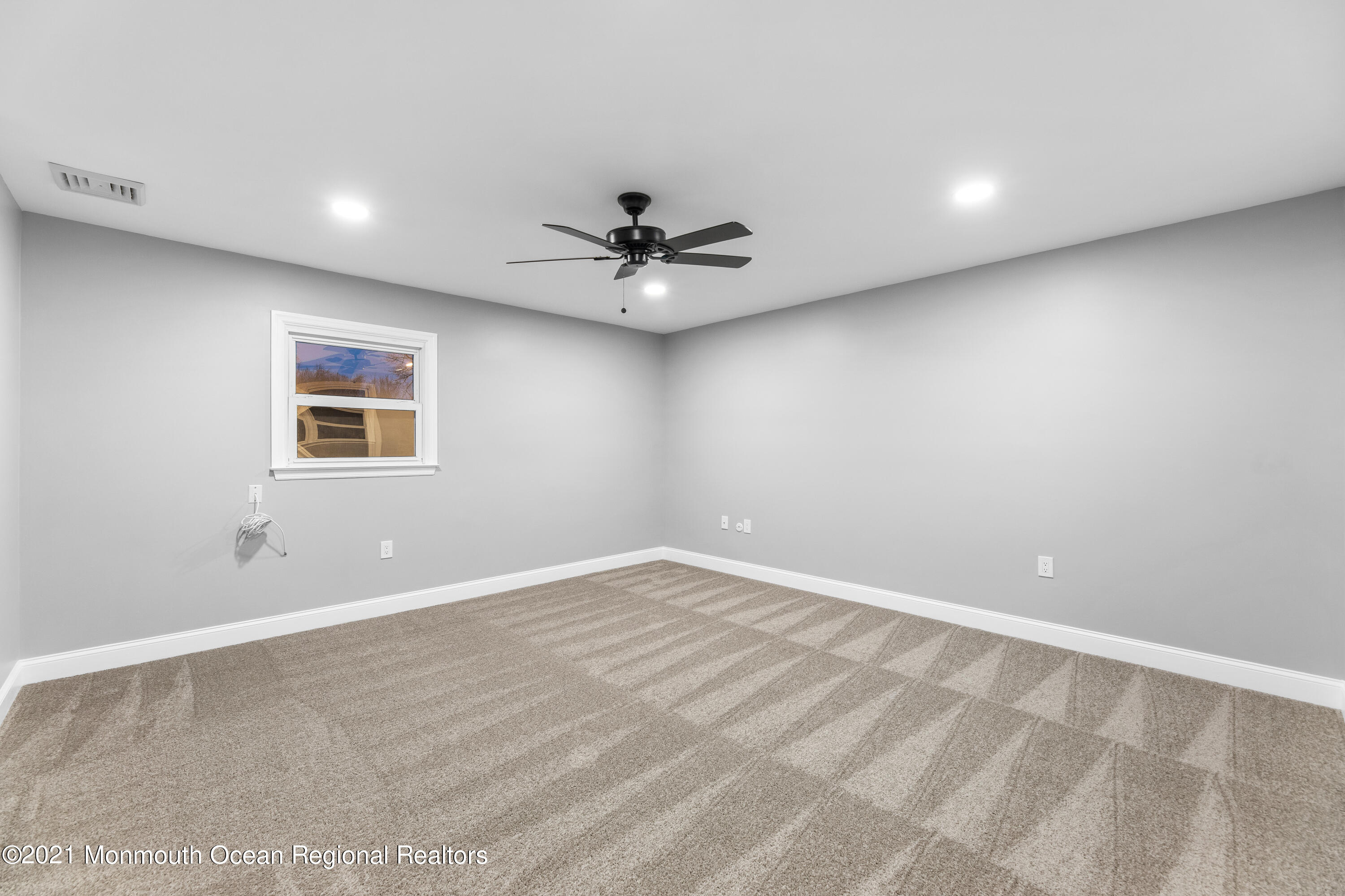 26 Squan Road Millstone Township, NJ 08510 - Photo 17 of 24 an empty room with chandelier fan and windows