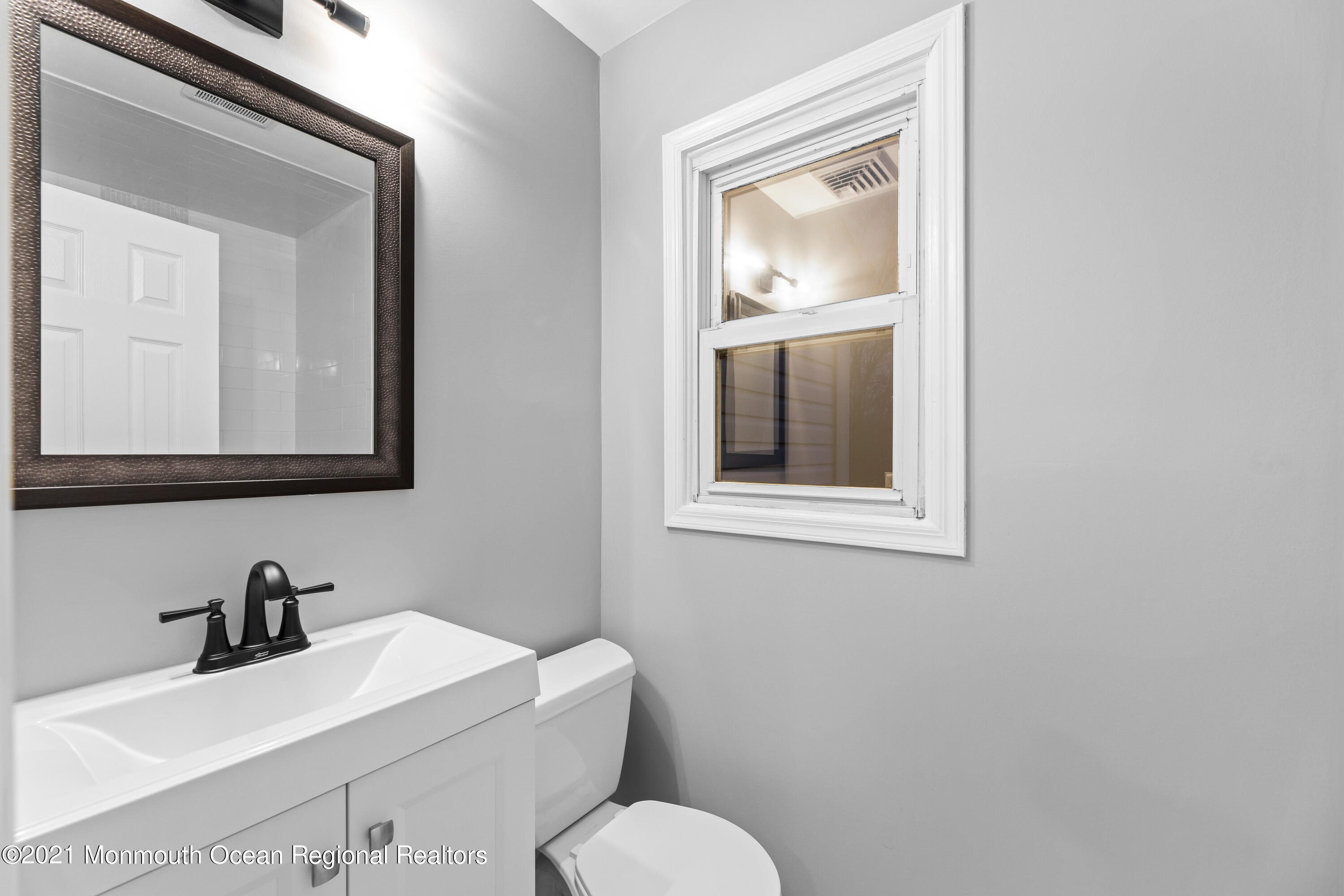 26 Squan Road Millstone Township, NJ 08510 - Photo 18 of 24 a bathroom with a toilet sink vanity and mirror