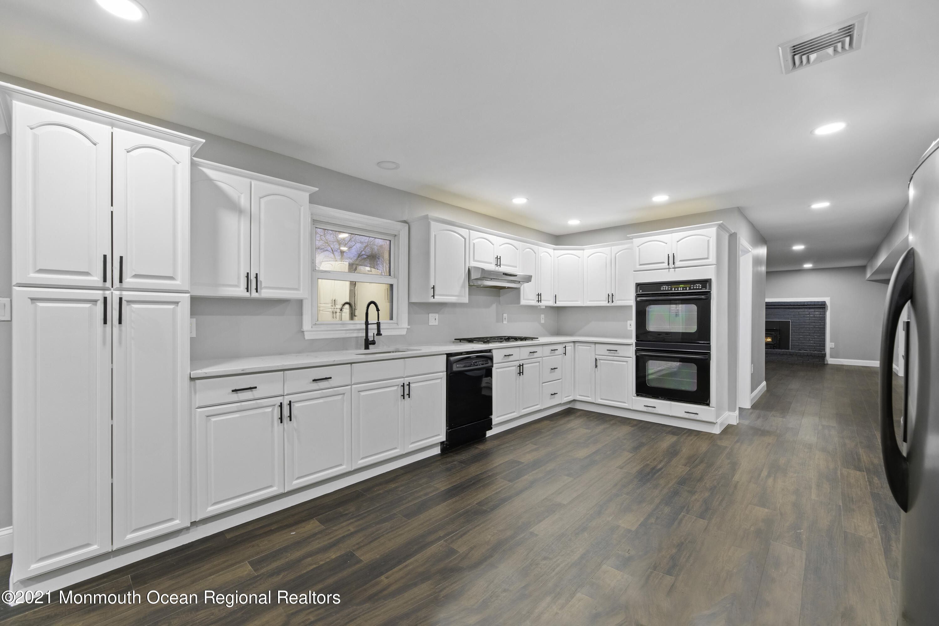 26 Squan Road Millstone Township, NJ 08510 - Photo 8 of 24 a large kitchen with stainless steel appliances granite countertop a large center island a stove a refrigerator with white cabinets and wooden floor