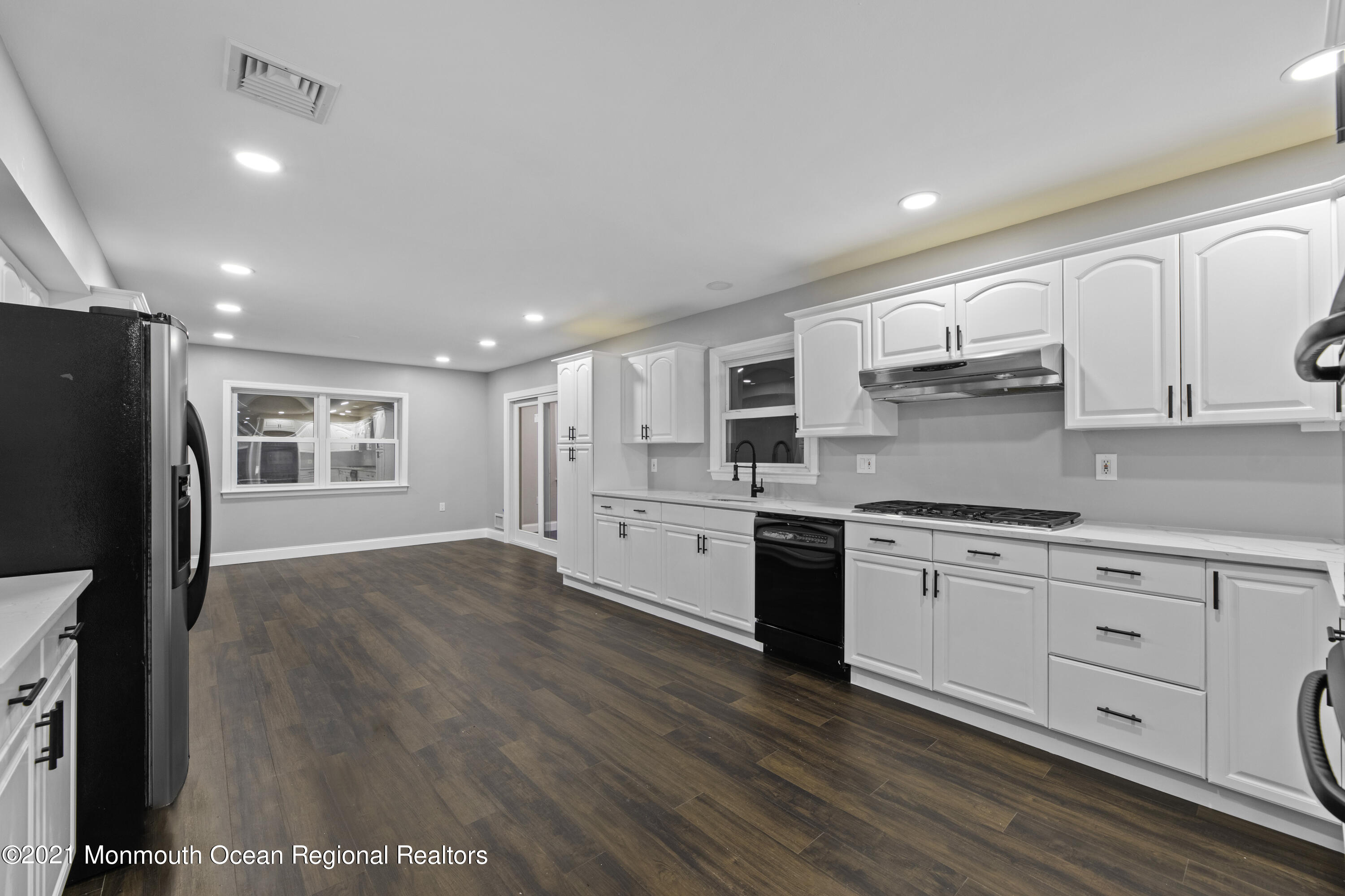 26 Squan Road Millstone Township, NJ 08510 - Photo 9 of 24 a kitchen with stainless steel appliances granite countertop a refrigerator a stove and white cabinets with wooden floors