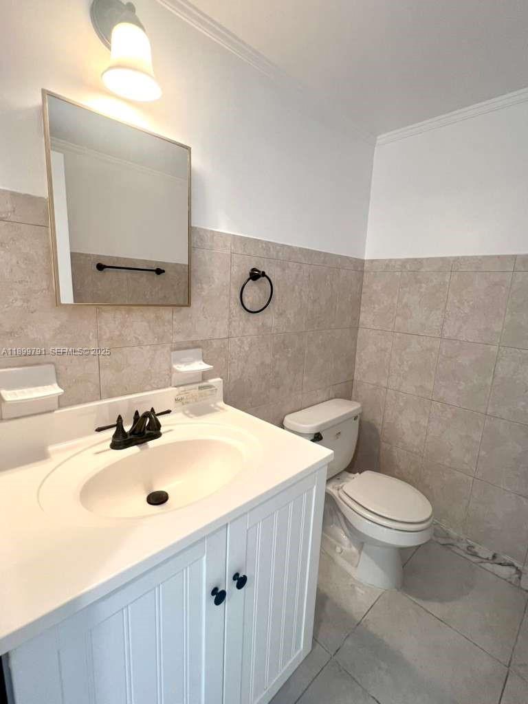 100 Golden Isles Drive, Unit 406 Hallandale Beach, FL 33009 - Photo 15 of 31 a bathroom with a sink toilet and mirror