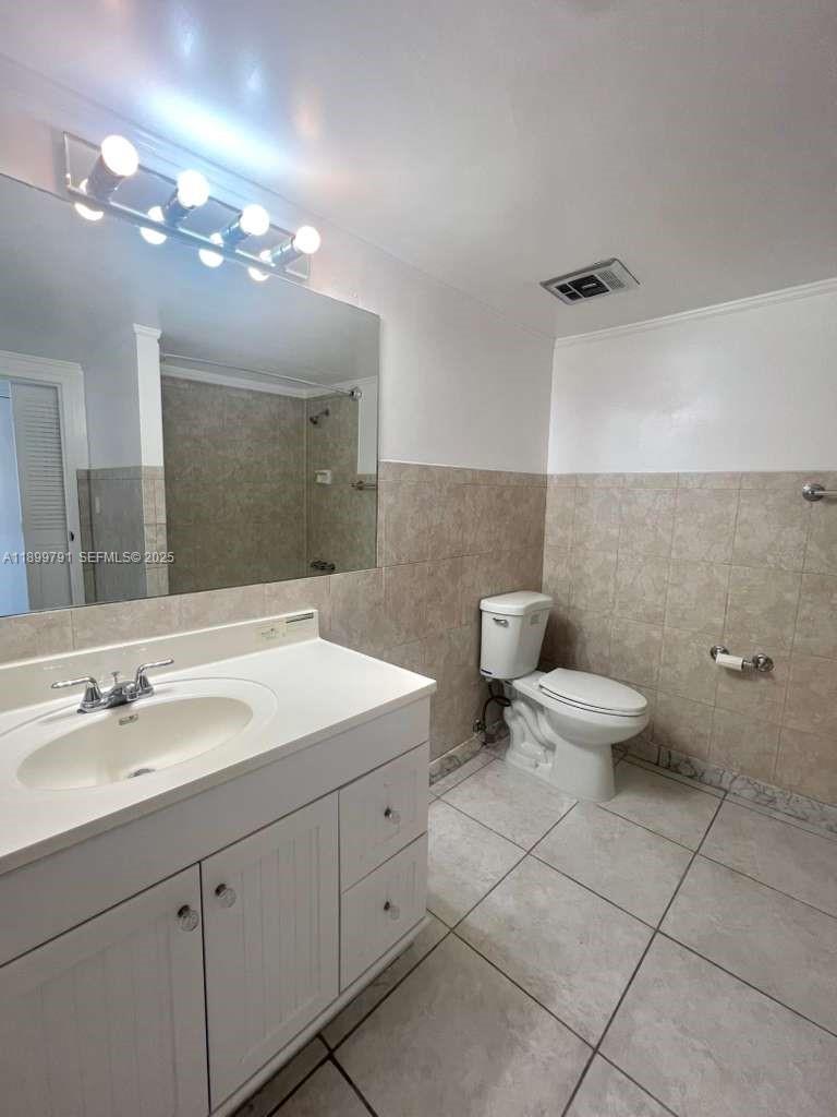 100 Golden Isles Drive, Unit 406 Hallandale Beach, FL 33009 - Photo 19 of 31 a bathroom with a toilet sink and mirror