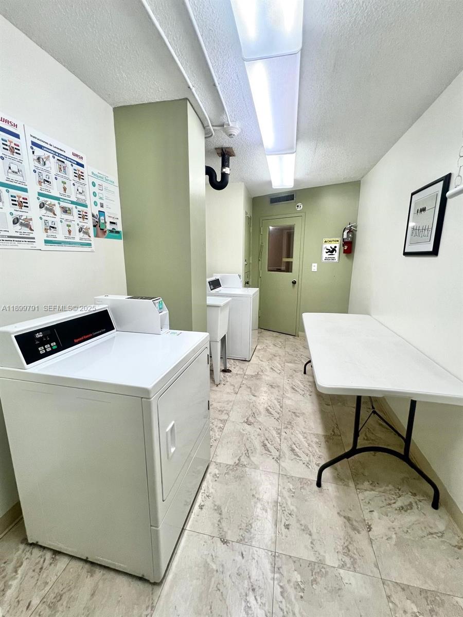 100 Golden Isles Drive, Unit 406 Hallandale Beach, FL 33009 - Photo 26 of 31 a living room with a couch and paintings on the wall