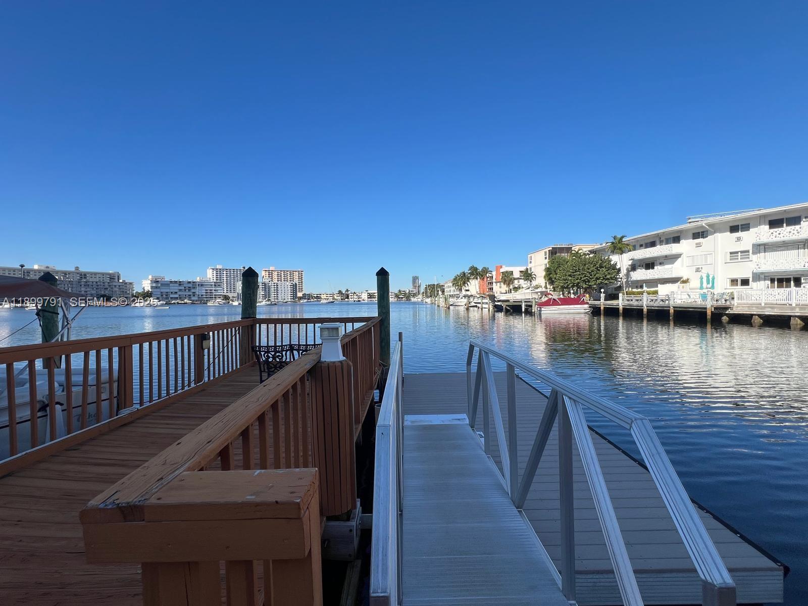 100 Golden Isles Drive, Unit 406 Hallandale Beach, FL 33009 - Photo 27 of 31 a view of a balcony with wooden chairs