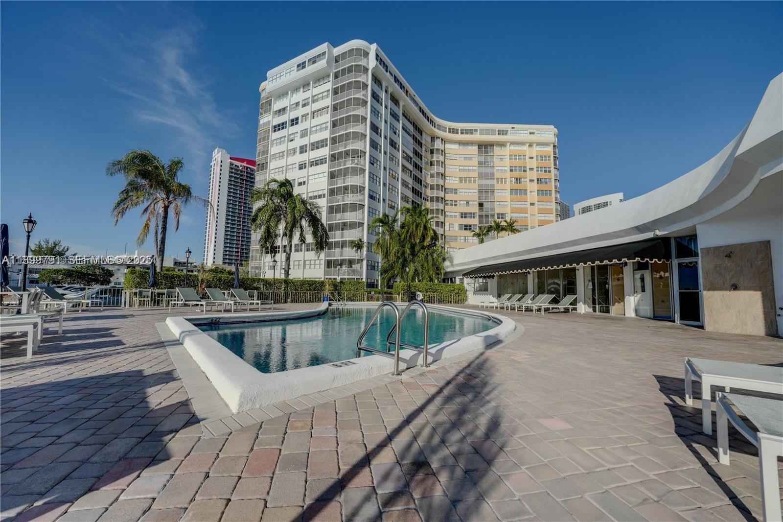 100 Golden Isles Drive, Unit 406 Hallandale Beach, FL 33009 - Photo 31 of 31 a view of a swimming pool with outdoor seating